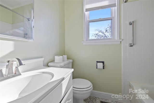 bathroom with toilet, vanity, ornamental molding, and tiled shower