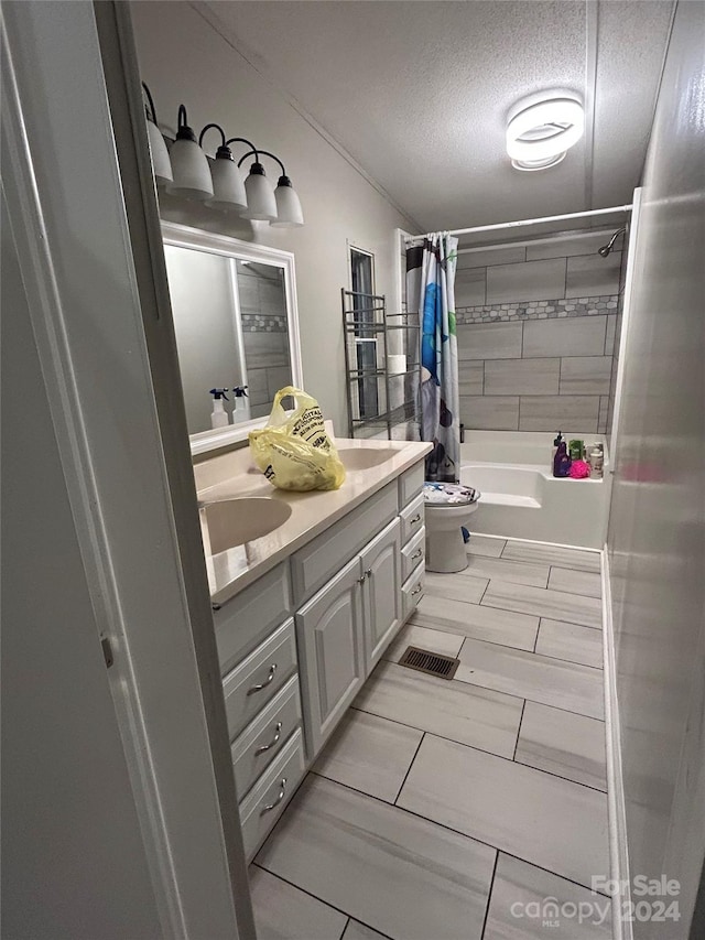 full bathroom featuring toilet, vanity, a textured ceiling, and shower / bathtub combination with curtain