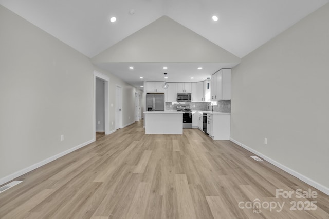 unfurnished living room featuring sink, light hardwood / wood-style floors, and high vaulted ceiling