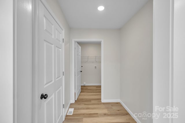 corridor with light hardwood / wood-style flooring