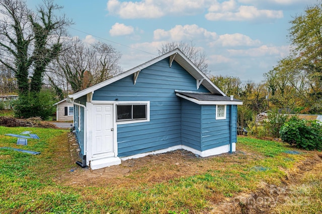 rear view of house featuring a yard