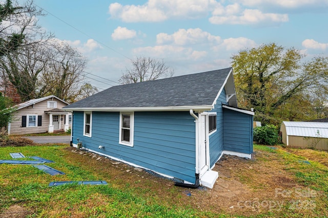 view of property exterior featuring a yard and a storage unit