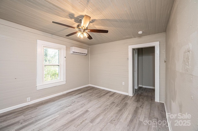 empty room featuring a wall mounted air conditioner, light hardwood / wood-style flooring, ceiling fan, and wood ceiling