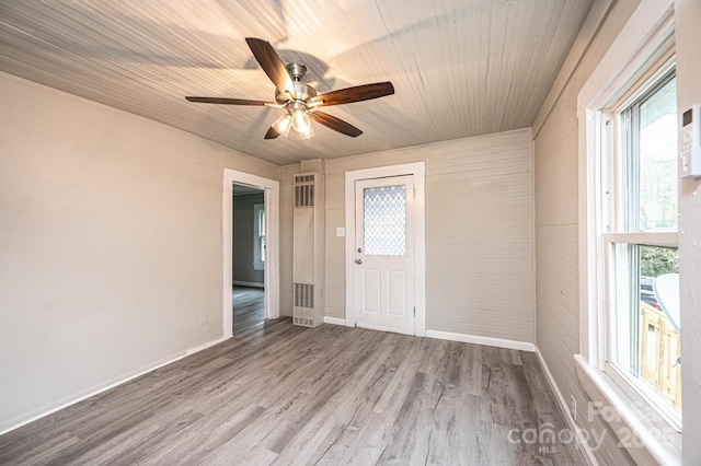 empty room featuring hardwood / wood-style floors, ceiling fan, and a healthy amount of sunlight