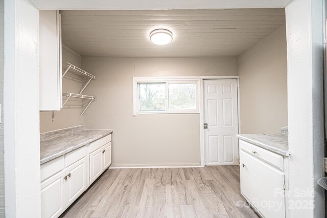 clothes washing area with light wood-type flooring