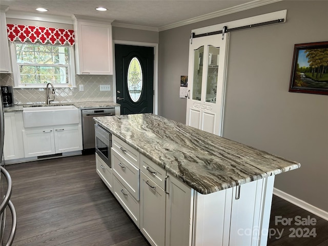 kitchen featuring appliances with stainless steel finishes, a barn door, white cabinetry, and dark wood-type flooring