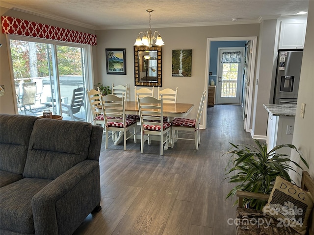 dining area with a textured ceiling, dark hardwood / wood-style flooring, crown molding, and an inviting chandelier