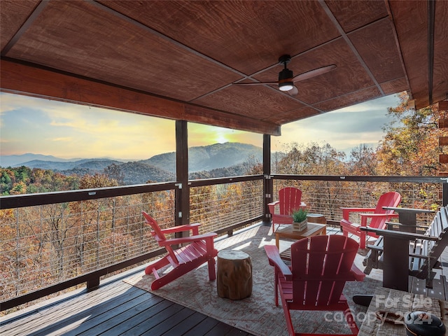 deck at dusk with ceiling fan and a mountain view