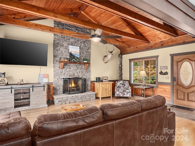 living room with a stone fireplace, hardwood / wood-style floors, lofted ceiling with beams, and wood ceiling