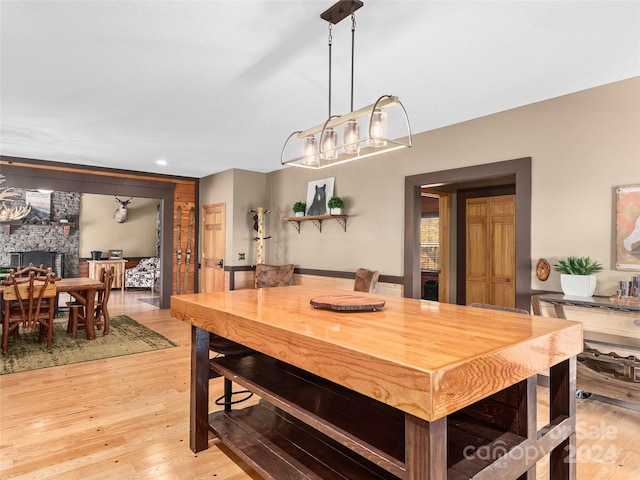 dining room with light wood-type flooring and a fireplace