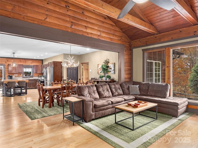 living room featuring vaulted ceiling with beams, light hardwood / wood-style flooring, wooden ceiling, and a chandelier