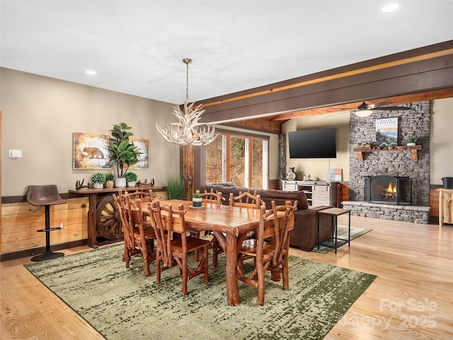 dining space with hardwood / wood-style flooring, a fireplace, and a notable chandelier