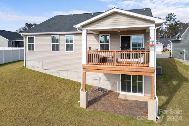 rear view of house featuring a yard, a deck, and ceiling fan