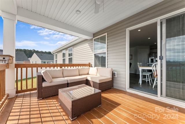 wooden terrace with an outdoor living space and ceiling fan