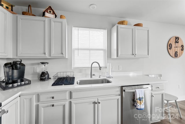 kitchen with hardwood / wood-style floors, sink, dishwasher, and white cabinets