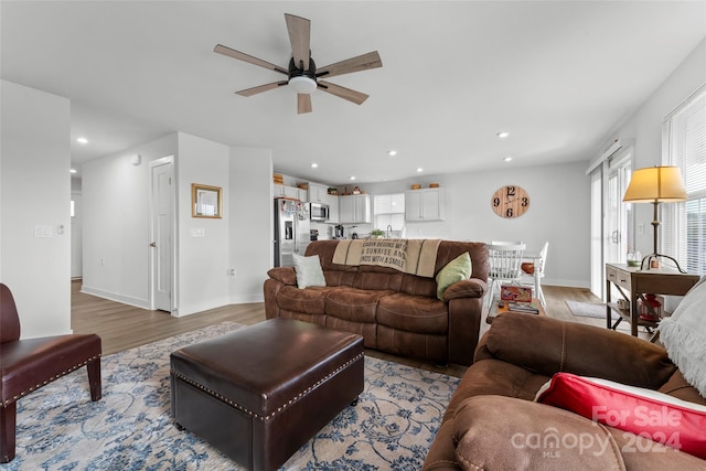 living room featuring light hardwood / wood-style flooring and ceiling fan