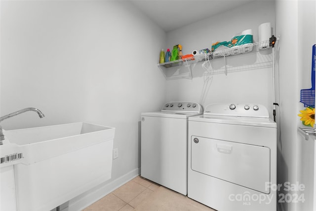 laundry area with sink, separate washer and dryer, and light tile patterned floors