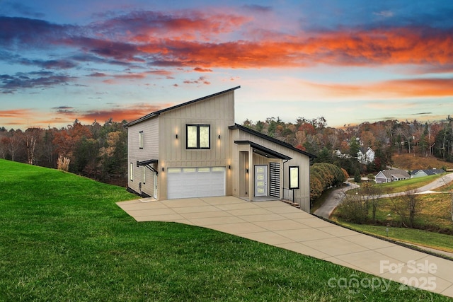 view of side of home featuring board and batten siding, a yard, and driveway