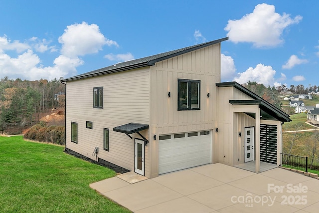 view of property exterior featuring an attached garage, board and batten siding, concrete driveway, and a yard