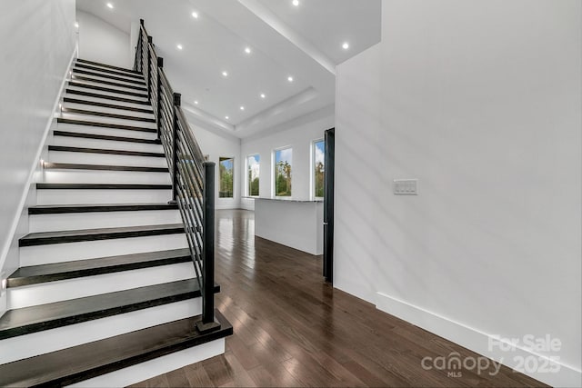 stairs featuring wood finished floors and recessed lighting