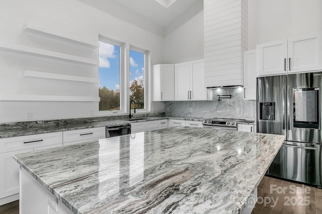 kitchen featuring appliances with stainless steel finishes, white cabinets, and light stone counters