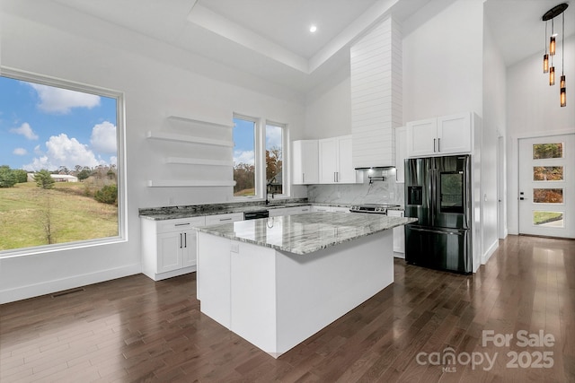 kitchen with a kitchen island, white cabinetry, fridge with ice dispenser, open shelves, and pendant lighting