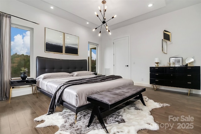 bedroom with baseboards, dark wood-type flooring, recessed lighting, and an inviting chandelier