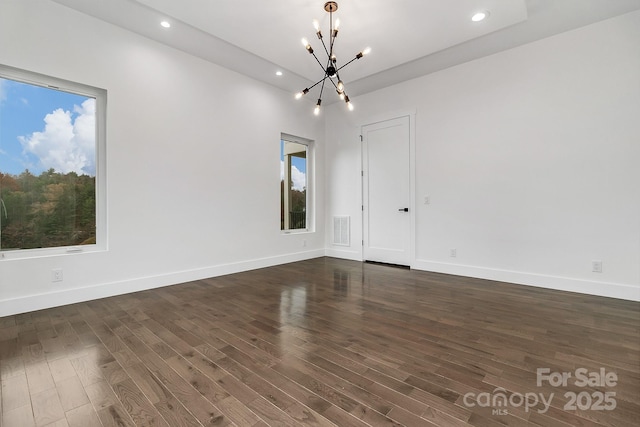 unfurnished room with dark wood-style floors, visible vents, and baseboards