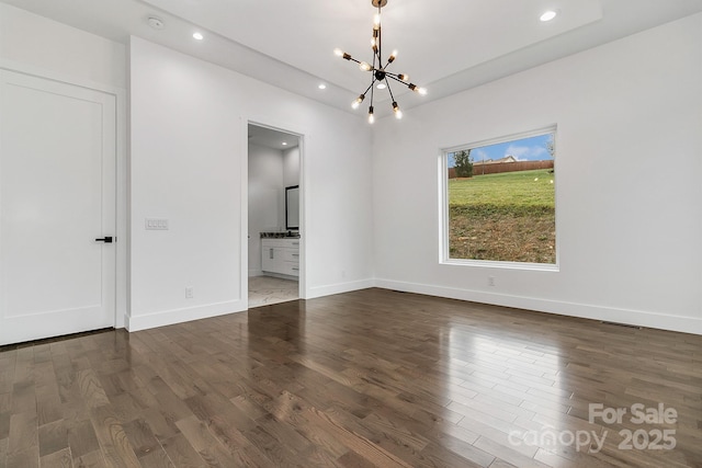 empty room featuring recessed lighting, a notable chandelier, baseboards, and wood finished floors