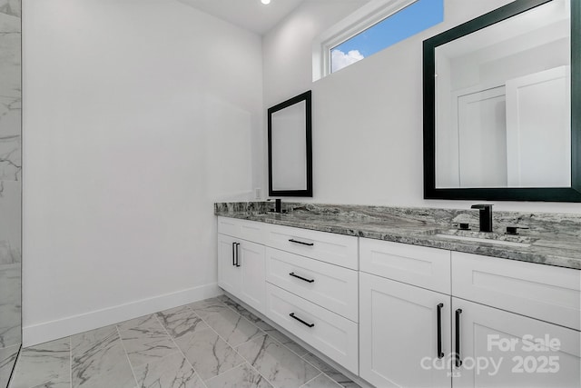 bathroom featuring marble finish floor, a sink, baseboards, and double vanity