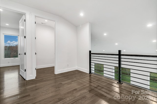 empty room with dark wood-style floors, visible vents, baseboards, and recessed lighting