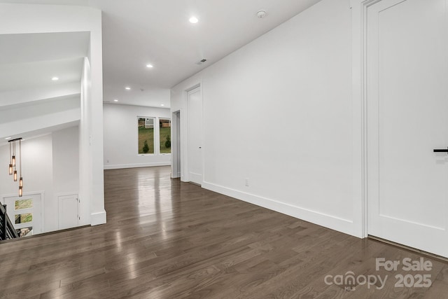 unfurnished living room with dark wood-style floors, baseboards, and recessed lighting