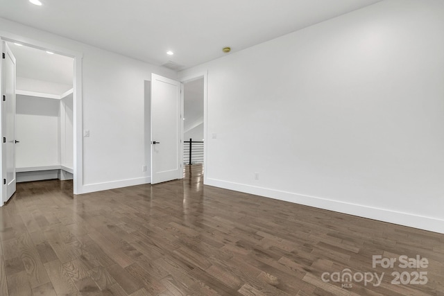 unfurnished bedroom with recessed lighting, dark wood finished floors, and baseboards