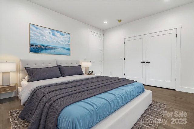 bedroom with dark wood-type flooring, recessed lighting, and a closet