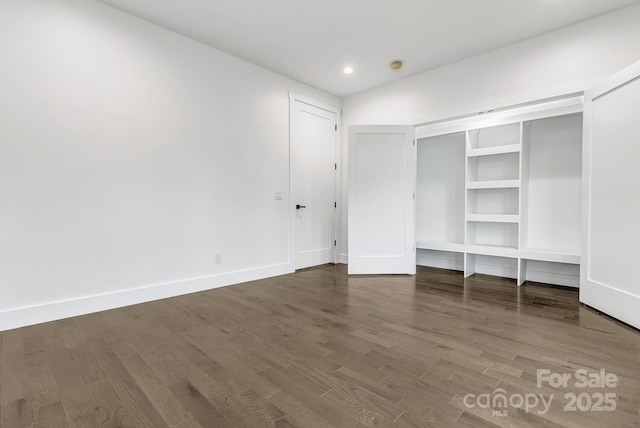 unfurnished bedroom featuring recessed lighting, wood finished floors, and baseboards