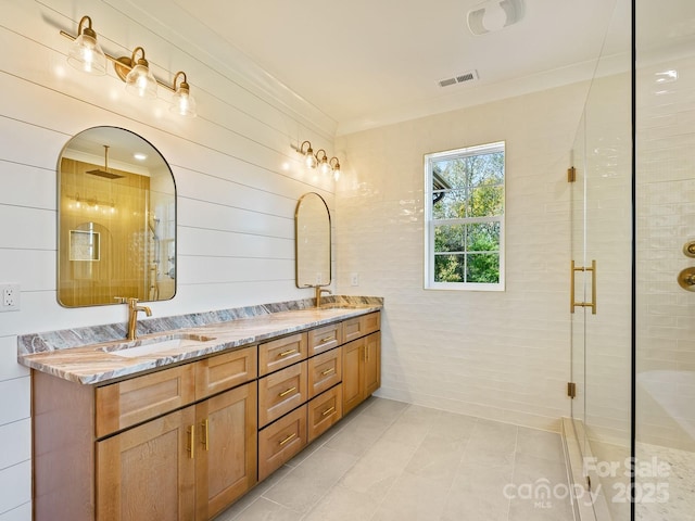 bathroom featuring vanity, crown molding, tile patterned floors, and walk in shower