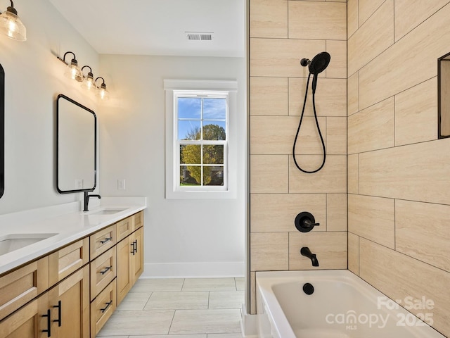 bathroom featuring vanity and tiled shower / bath combo