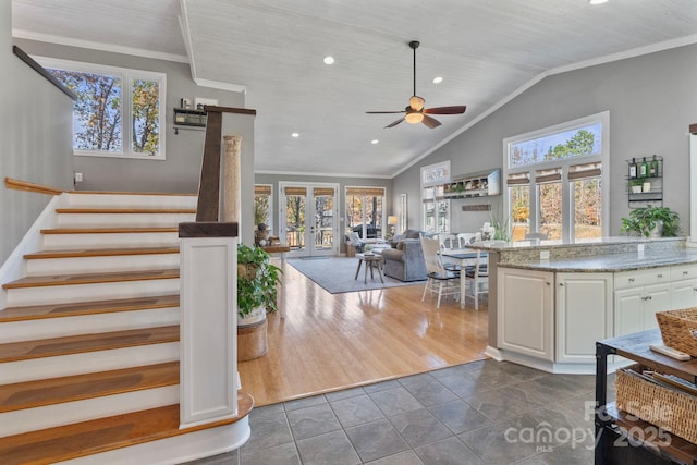 interior space featuring tile patterned floors, vaulted ceiling, ceiling fan, crown molding, and wooden ceiling