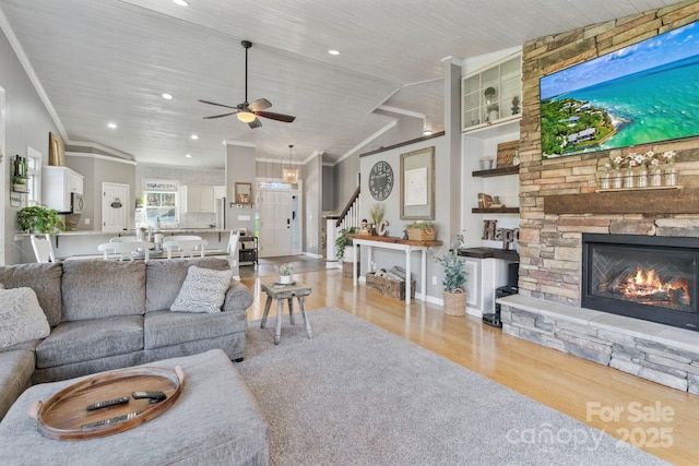 living room featuring lofted ceiling, ceiling fan, light wood-type flooring, a fireplace, and wood ceiling