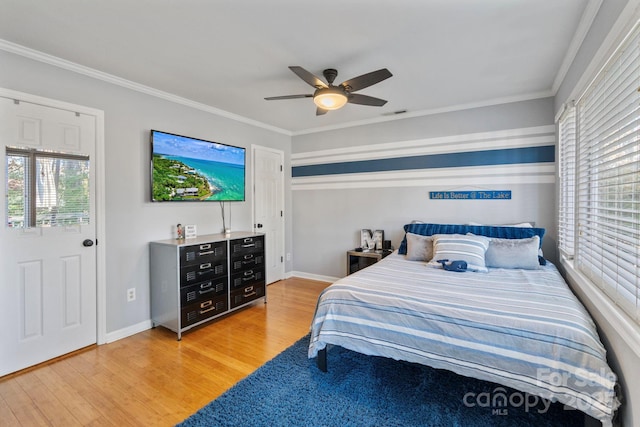 bedroom featuring light hardwood / wood-style flooring, ceiling fan, and crown molding