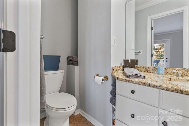 bathroom with tile patterned floors, vanity, toilet, and ornamental molding