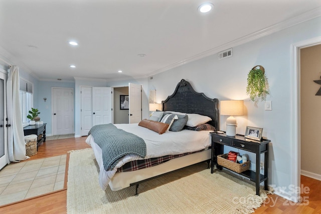 bedroom with light wood-type flooring and ornamental molding