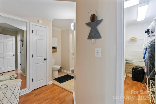 hall with hardwood / wood-style floors and crown molding