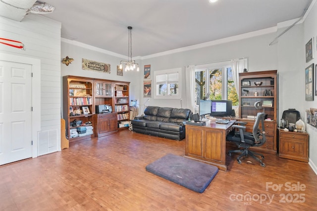 office space featuring ornamental molding, wood-type flooring, and a notable chandelier