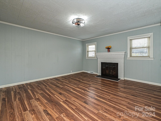 unfurnished living room featuring dark wood-type flooring, wood walls, crown molding, and a fireplace