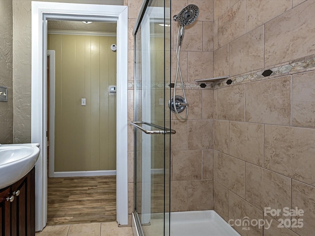 bathroom with tile patterned flooring, walk in shower, ornamental molding, and vanity