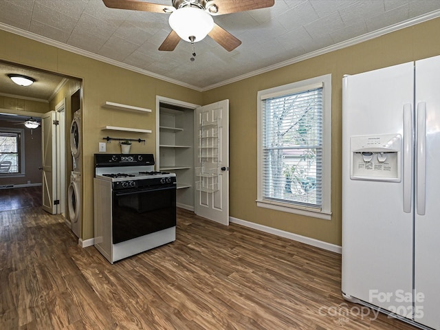 kitchen featuring crown molding, white fridge with ice dispenser, range with gas cooktop, stacked washer / dryer, and dark wood-type flooring