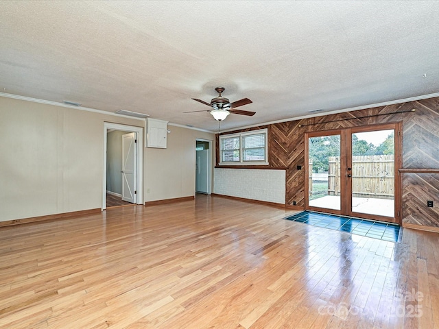 unfurnished room with light hardwood / wood-style floors, a textured ceiling, and ornamental molding