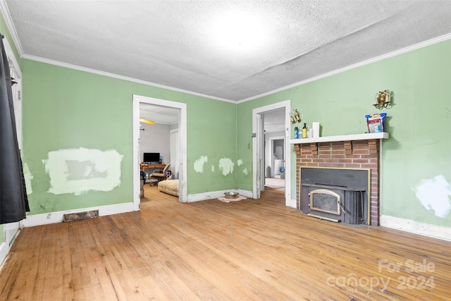 living room featuring wood-type flooring, a textured ceiling, and crown molding