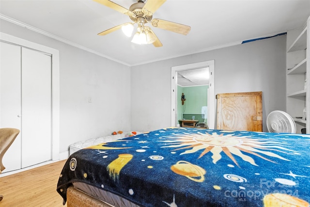 bedroom with ornamental molding, a closet, wood-type flooring, and ceiling fan